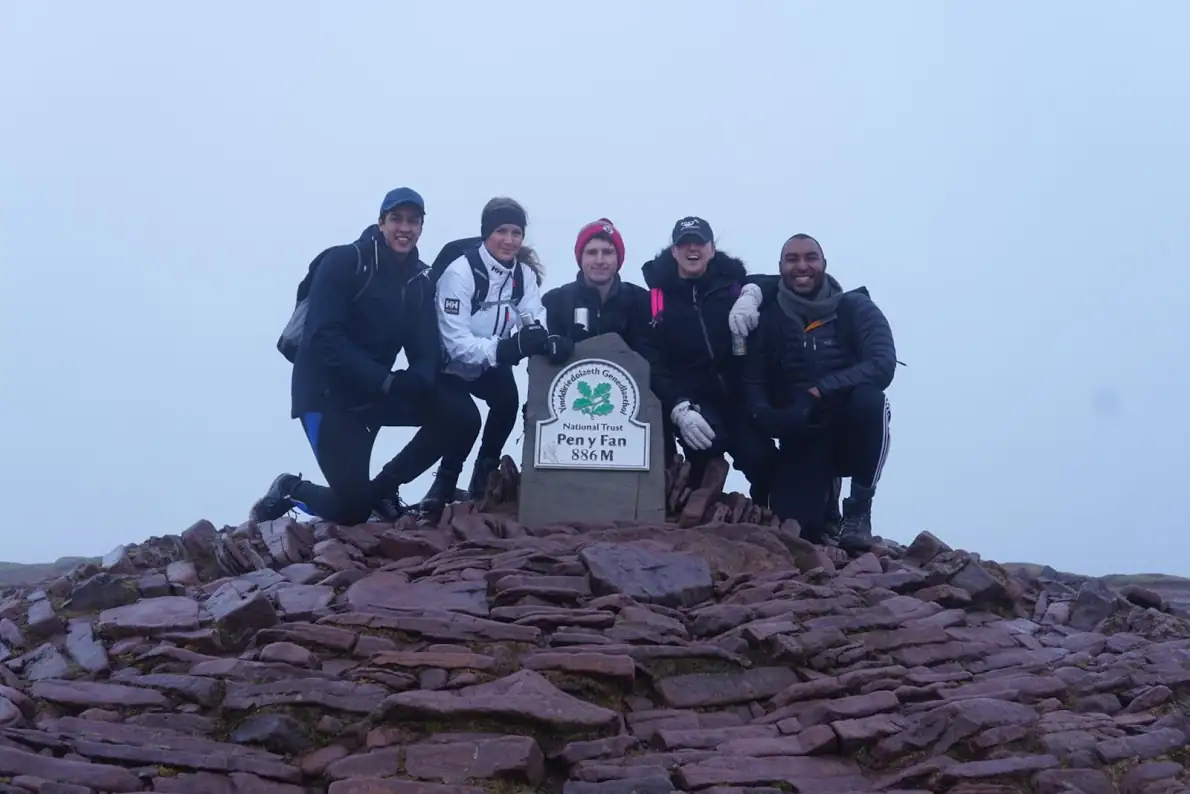 Photo of five colleagues at the summit of Pen y Fan, Wales.
